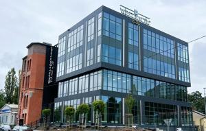 ein hohes Glasgebäude mit einem Schild darauf in der Unterkunft West Baltic City in Stettin