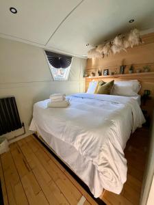 a bedroom with a large white bed with a window at The Floating Terrarium in London