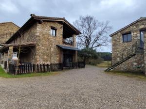 an old stone house with a fence in front of it at Casa rural Ca l'Antón in Sant Miquel de Campmajor