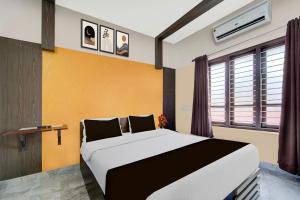a bedroom with a large bed and a window at Super Hotel O Kazhakkoottam Near Technopark Phase 3 in Trivandrum