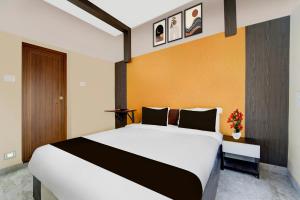 a bedroom with a large bed in a room at Super Hotel O Kazhakkoottam Near Technopark Phase 3 in Trivandrum