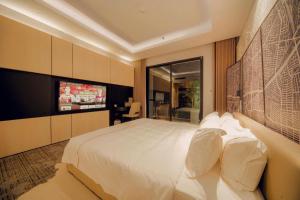 a bedroom with a large bed and a flat screen tv at X-Digital HOTEL in Bắc Ninh