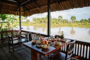 a table with food on it with a view of a river at Thala Tra Vinh in Trà Vinh