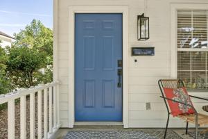 a blue door on a house with a chair at 322 S, 5th Street Unit A townhouse in Fernandina Beach