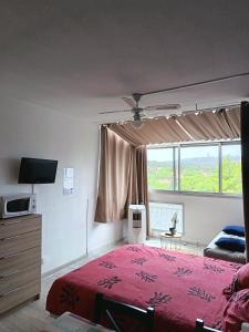 a bedroom with a red bed and a window at Appartement au Cap d'Agde in Cap d'Agde