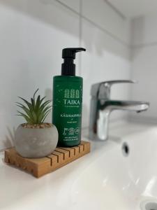 a bottle of shampoo sitting next to a sink at Arctic Willamo Studio- Rovaniemi in Rovaniemi +13 photos