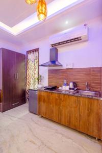 Una cocina con gabinetes de madera y un fregadero. en Hotel Ashiyana Elite I Near Dlf Golf Course Road I Gurgaon, en Gurgaon