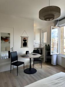 una stanza con un tavolo, due sedie e un letto di L'Appartement du Forum - Reims centre Cathédrale a Reims