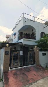 a white house with a gate and a balcony at Cozy Home near Fateh Sagar! in Udaipur