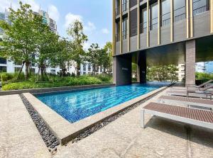 a swimming pool in front of a building at Noble Bangkok Condo in Bangkok