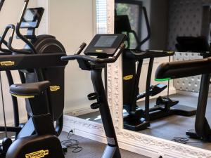 a row of treadmills in a gym with a mirror at Le Louise Hotel Brussels - MGallery Collection in Brussels