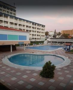 a large swimming pool in front of a large building at Apartahotel Estudio 331 in Matalascañas