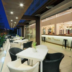 a restaurant with white tables and chairs and a bar at Apartahotel Estudio 331 in Matalascañas
