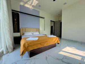 a bedroom with a large bed with orange sheets at Staymist - Pool and Pause Villa in Nagaon +33 photos