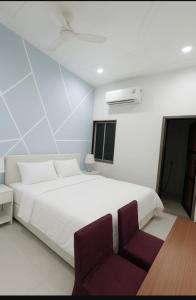 1 Schlafzimmer mit einem großen weißen Bett und 2 Stühlen in der Unterkunft Hotel Balram Palace Khatu Shyam in Rīngas