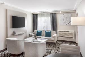 a living room with a couch and a tv at The Ashi, an Ascend Collection Hotel in North Brunswick