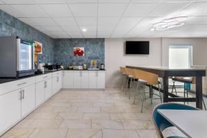 a kitchen with white cabinets and a table and chairs at Quality Inn Chattanooga Hamilton Place in Chattanooga