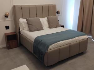 a bedroom with a large bed with a large headboard at White House River Manor in Upington