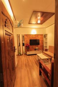 a living room with a fireplace and a television at GALAXY INTERNATIONAL Inn in Munnar