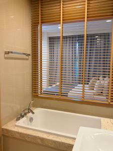 a bathroom with a bath tub and a window at The H2O Khao Yai in Ban Rai Khlong Sai +12 photos