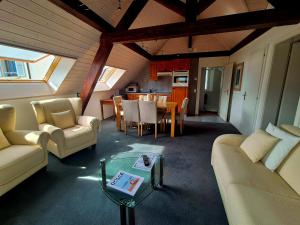 a living room with two couches and a table at Pavillon Bon Rivage in La Tour-de-Peilz