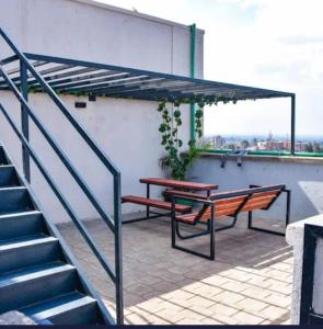 a patio with two benches and a table and stairs at CK place in Nairobi