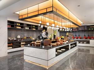a restaurant with a counter with food on it at Hampton by Hilton Hefei Xinqiao International Airport in Hefei