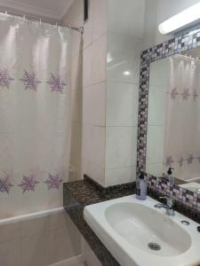 a bathroom with a sink and a shower curtain at Apartahotel Estudio 332 in Matalascañas +13 photos