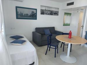a small living room with a table and a couch at Apartahotel Estudio 332 in Matalascañas