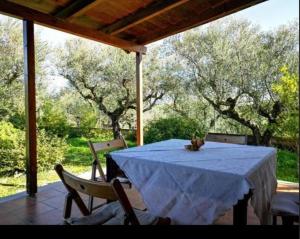 a table and chairs on a porch with trees at Villa del Alma in Planos