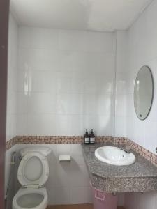 a bathroom with a toilet and a sink at บ้านทรัพย์มงคล in Ban Nua Khlong