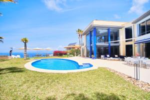 eine Villa mit einem Swimmingpool vor einem Haus in der Unterkunft Villa Bay Blue in Llucmajor