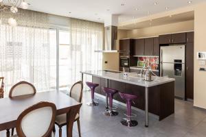 a kitchen with purple bar stools and a table at Vasso Villa in Vravrona
