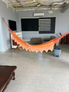 - un hamac orange dans une chambre avec une table dans l'établissement Casa no Lago em Corumbá 4, à Alexânia