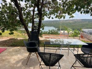 a table and chairs with a view of a lake at Casa no Lago em Corumbá 4 in Alexânia