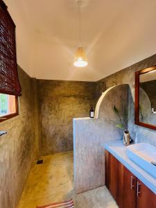 a bathroom with a sink and a mirror at La Sirena Villa in Talpe