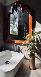 a bathroom with a sink and a potted plant at La Sirena Villa in Talpe
