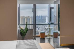 a bedroom with a view of a city from a window at VKing High-Altitude River View Hotel in Nan'an