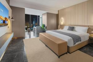 a bedroom with a large bed and a living room at VKing High-Altitude River View Hotel in Nan'an