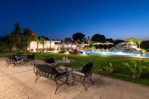 a patio with chairs and a table and a pool at Vento Estivo Mansion in Pastida
