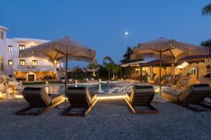 a group of chairs and umbrellas next to a pool at Vento Estivo Mansion in Pastida