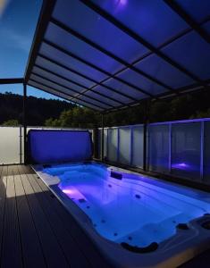 a large swimming pool under a roof with blue lights at Cozy Swiss Retreat - Scenic Swiss Villa Close to Bern & Interlaken in Frinvillier