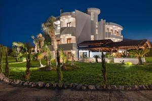 a large white building with palm trees in front of it at Vento Estivo Mansion in Pastida +51 photos