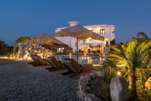 a house on the beach with lounge chairs and a pool at Vento Estivo Mansion in Pastida
