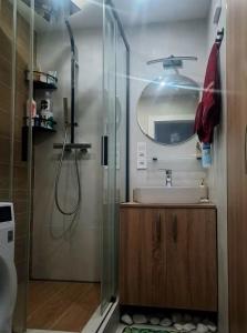 a bathroom with a shower and a sink and a mirror at Lovely flat in a great location in Košice