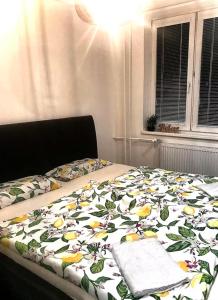 a bed with a blanket with flowers on it at Lovely flat in a great location in Košice