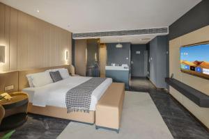 a bedroom with a large bed and a flat screen tv at VKing High-Altitude River View Hotel in Nan'an