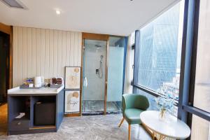 a bathroom with a shower and a table and a chair at VKing High-Altitude River View Hotel in Nan'an
