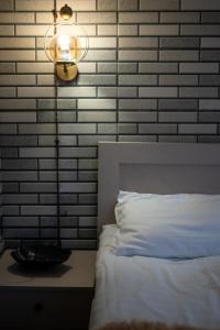 una lámpara sentada junto a una cama en un dormitorio en Kera Rooms, en Telavi