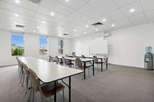 a conference room with tables and chairs and a whiteboard at Comfort Hotel Dandenong in Dandenong